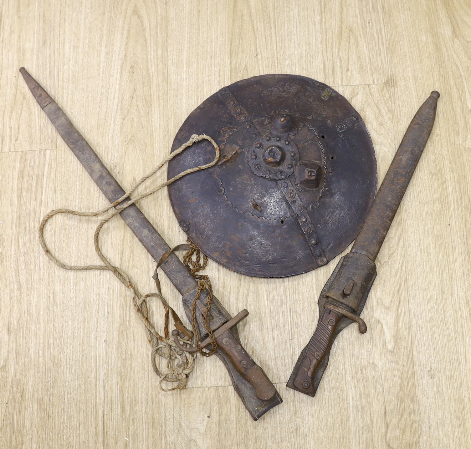 A 19th century iron shield, North African? and a WWI German bayonet and an Ottoman bayonet, shield 34cm